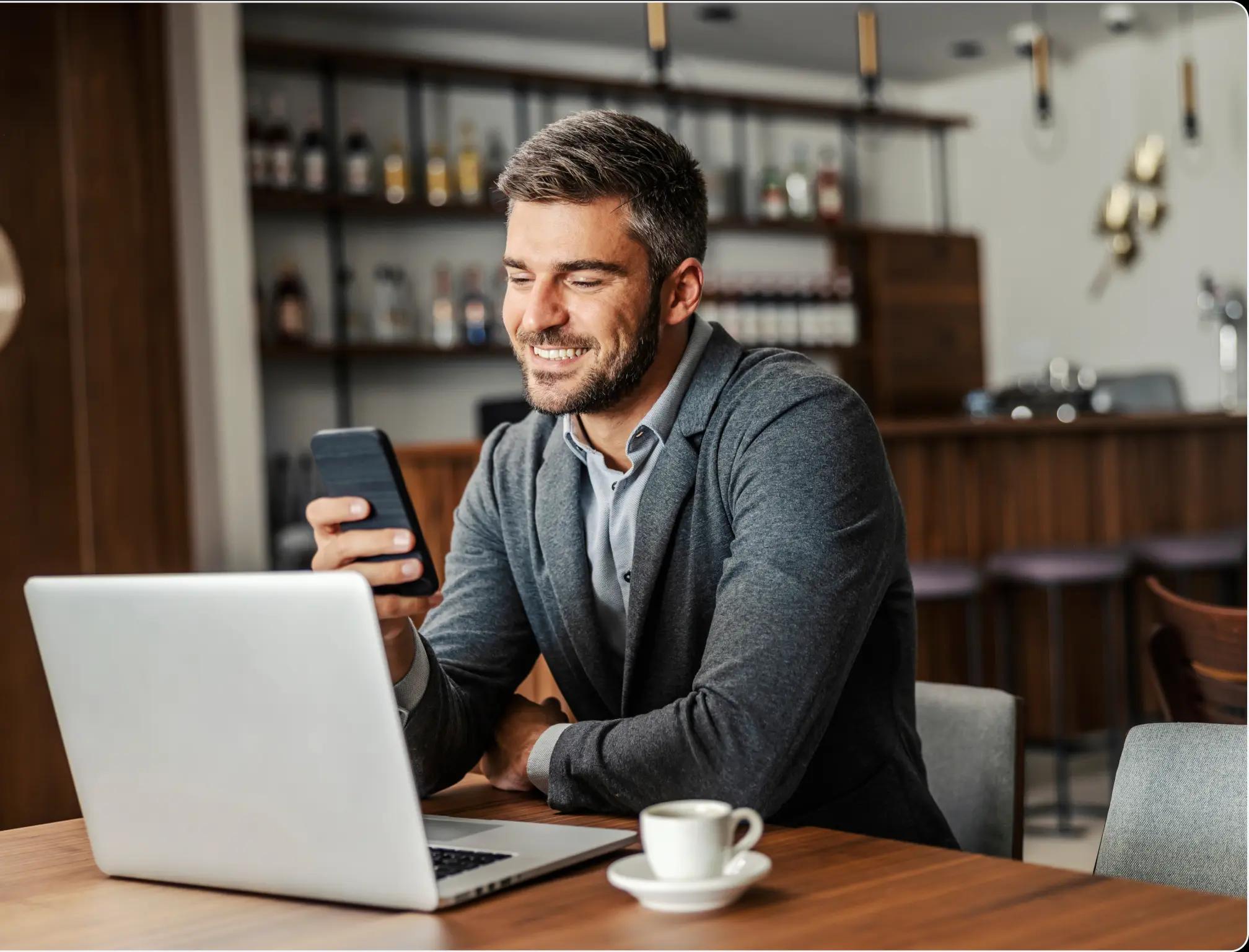 a man using a computer and a cellphone